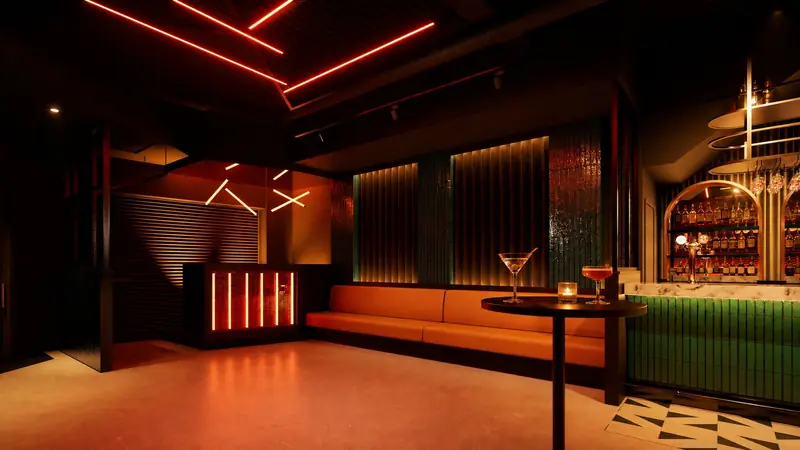 The lounge, washed in red neon