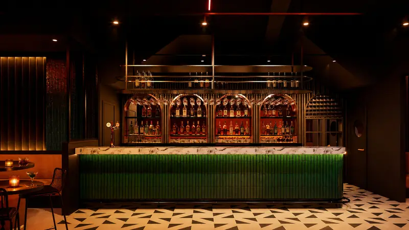 The bar, clad in green tile beneath a marble top